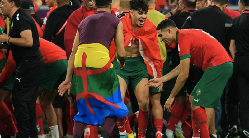 Morocco's reserve goalkeeper Munir Mohamedi can be seen with Amazigh flag around his waist as the Moroccan team celebrate their win against Spain on 6 December 2022